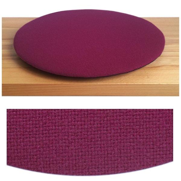 Das foto zeigt eine runde sitzauflage der firma discus. Das sitzkissen verjüngt sich zum rand hin und bildet eine schattenfuge aus. Die farbe der sitzauflage ist violett.