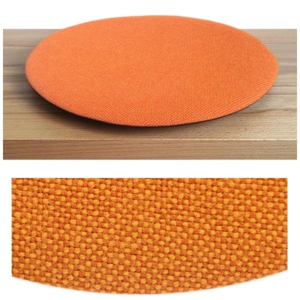 Das foto zeigt eine runde sitzauflage der firma discus. Das sitzkissen verjüngt sich zum rand hin und bildet eine schattenfuge aus. Die farbe der sitzauflage ist orange-rot meliert meliert.