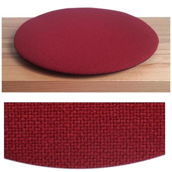 Das foto zeigt eine runde sitzauflage der firma discus. Das sitzkissen verjüngt sich zum rand hin und bildet eine schattenfuge aus. Die farbe der sitzauflage ist  rot.