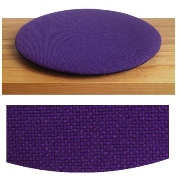 Das foto zeigt eine runde sitzauflage der firma discus. Das sitzkissen verjüngt sich zum rand hin und bildet eine schattenfuge aus. Die farbe der sitzauflage ist dunkelblau-violett meliert.